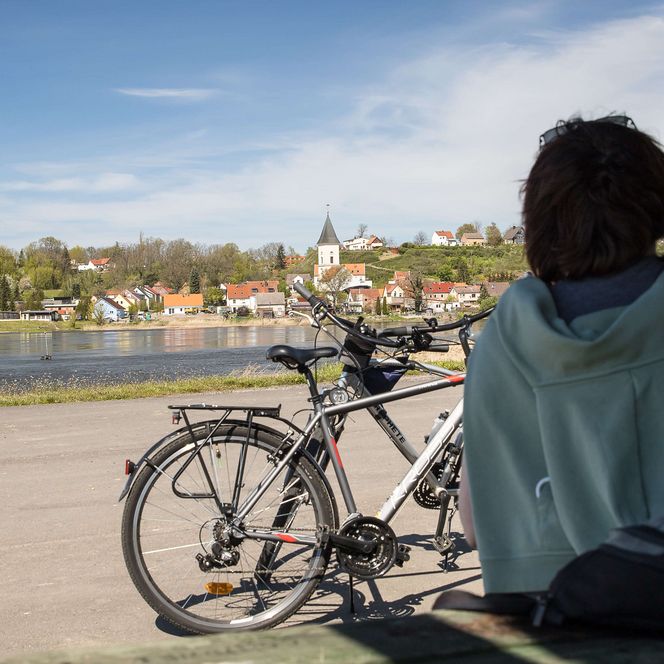Radfahrerin pausiert in Lebus mit einem Ausblick auf die Stadt