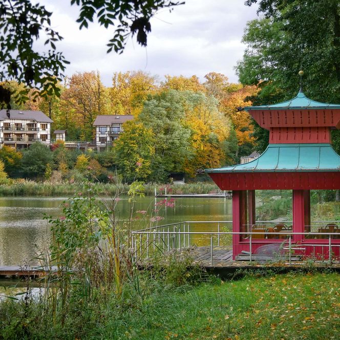 Blick auf den Madlitzer See, davor ein roter Seepavillion