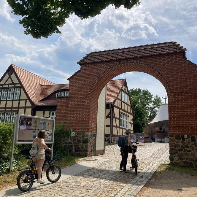 Burg Storkow Eingang Innenhof mit Radfahrern im Sommer