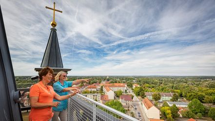 Zwei Frauen stehen auf dem Turm der Stadtpfarrkirche Müncheberg und schauen in die Weite und auf die Stadt