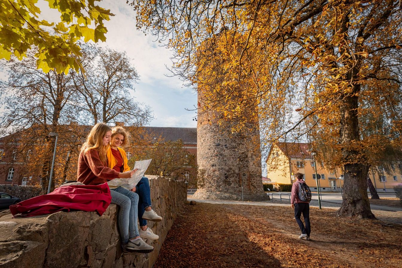 drei Leute befinden sich vor dem Storchenturm in Müncheberg im Herbst