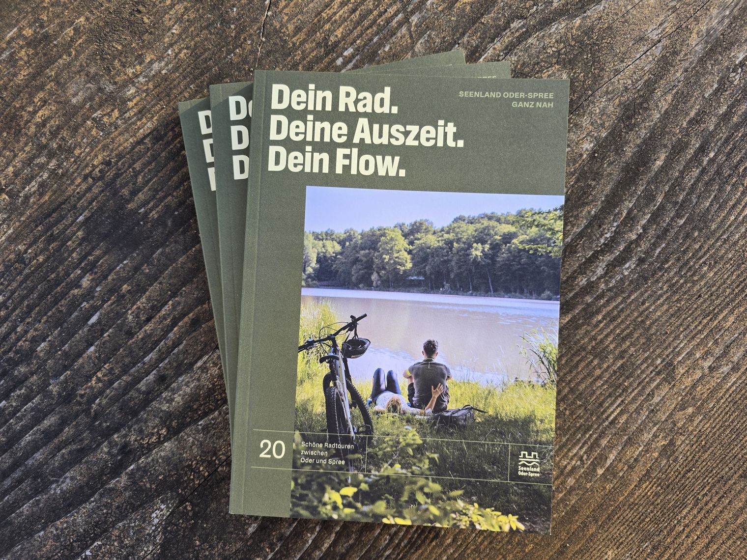 Radbroschüre liegt aufgefächert auf einem Holzuntergrund