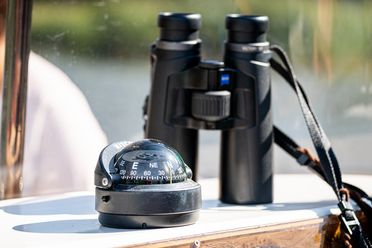 Fernglas und Kompass auf einem Boot