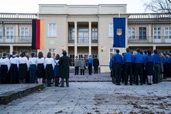 Filmausschnitt: DDR Morgenapell an einer Schule. Schüler stehen aufgereiht in Uniform. 