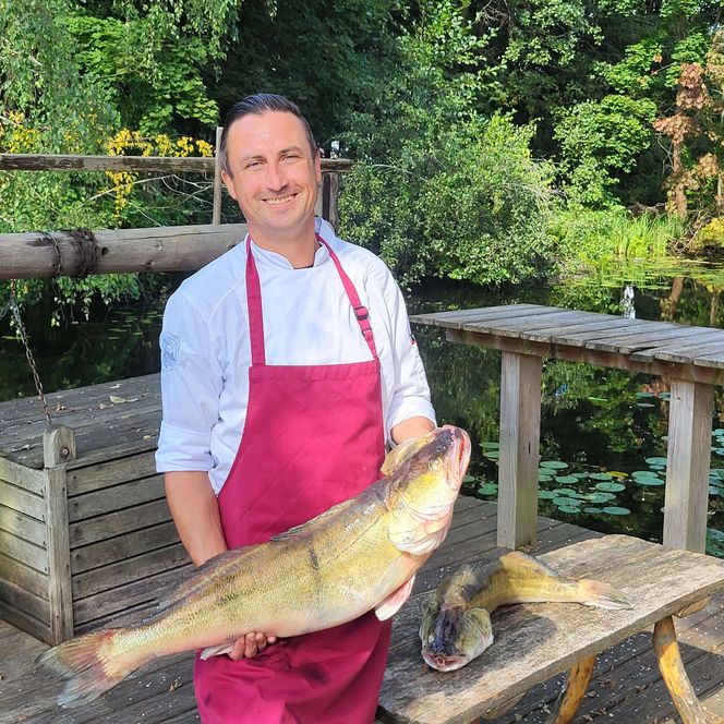 Küchenchef Andreas Neugebauer Fischhaus mit Fisch im Arm im Sommer