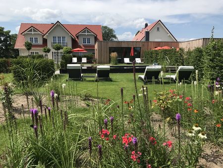 Blick aus dem Garten auf das Landhaus Alwine mit Poolbereich